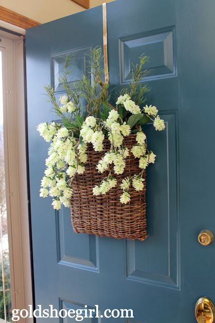 Krásné jarní dekorace na vchodové dveře jejichž základem je proutěný košík