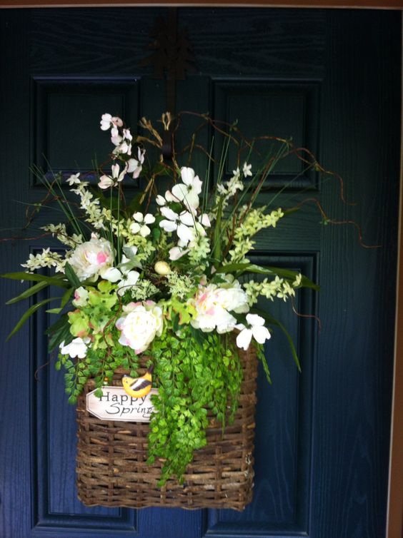Krásné jarní dekorace na vchodové dveře jejichž základem je proutěný košík