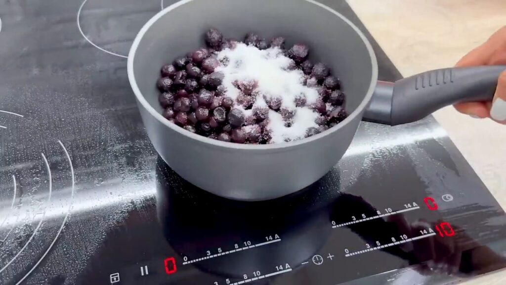 Úžasný dezert s borůvkovou náplní a jogurtovým krémem, zdobený mandlovými lupínky – ideální k lahodné kávě