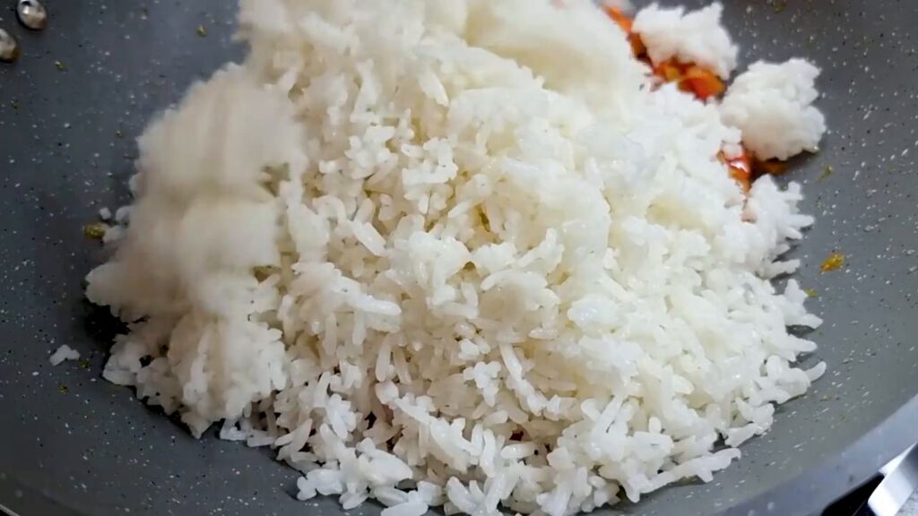 Smažené kuřecí kousky s cibulí, zdobené koprem a s přílohou rýže se zeleninou – oběd hotový!