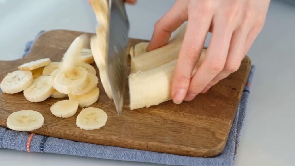 Karamelizované banány se smetanovým krémem podávané ve sklenicích, zdobené čokoládou