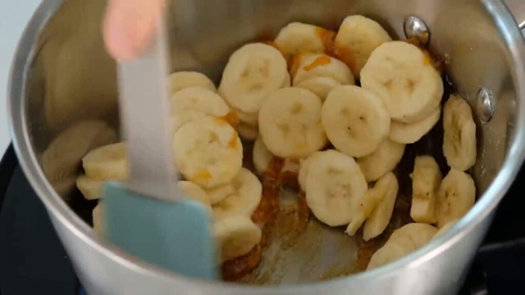 Karamelizované banány se smetanovým krémem podávané ve sklenicích, zdobené čokoládou