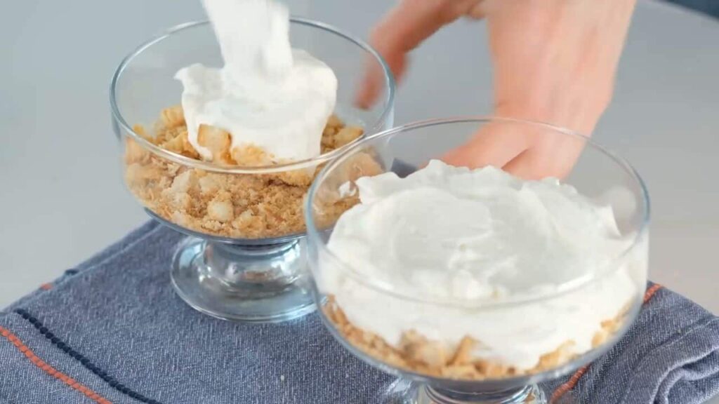 Karamelizované banány se smetanovým krémem podávané ve sklenicích, zdobené čokoládou