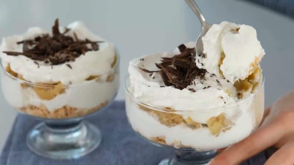 Karamelizované banány se smetanovým krémem podávané ve sklenicích, zdobené čokoládou