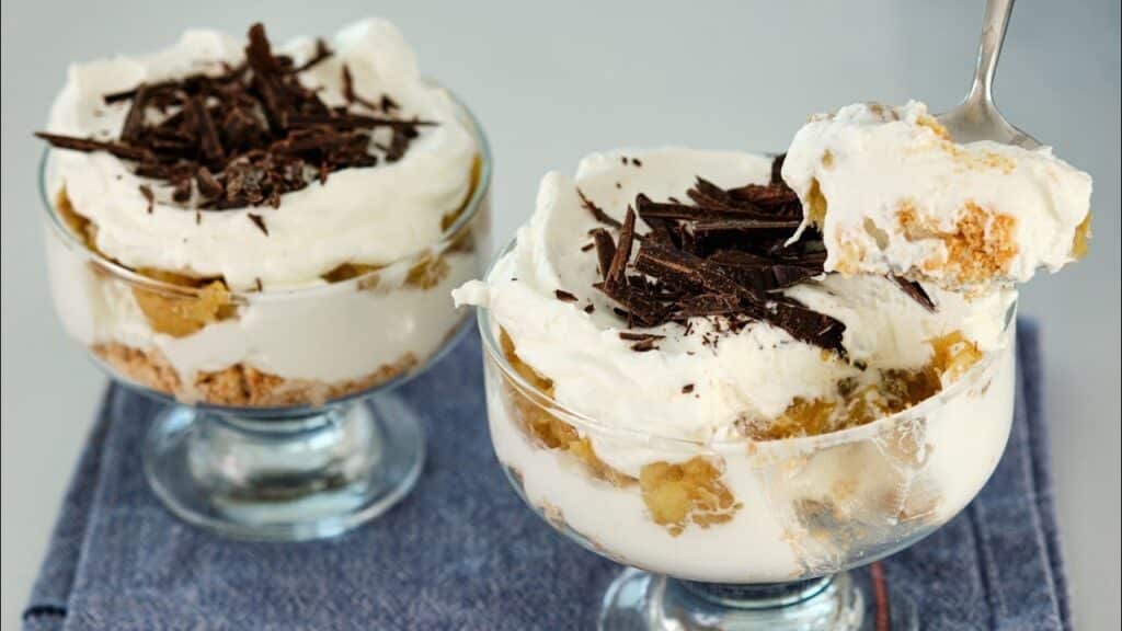 Karamelizované banány se smetanovým krémem podávané ve sklenicích, zdobené čokoládou