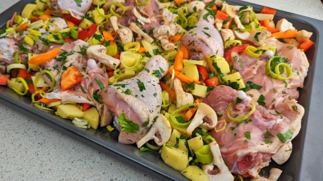 Kuřecí stehna se zeleninou na jednom plechu přelitá jemnou sladkastou omáčkou podávané s chutným salátem Kuřecí stehna se zeleninou na jednom plechu přelitá jemnou sladkastou omáčkou podávané s chutným salátem