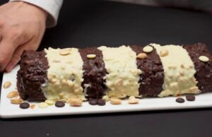 Dvoubarevná čokoládová roláda z vlašských oříšku politá tmavou a bílou čokoládou s arašídy