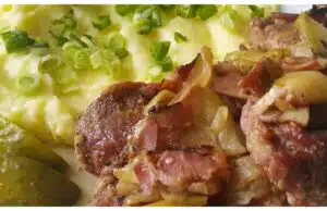 Pečená krkovice na česneku s anglickou slaninou a cibulí podávaná s bramborovou kaší Poctivá pečená krkovice na česneku se slaninou a cibulí: domácí oběd, který si zamilujete