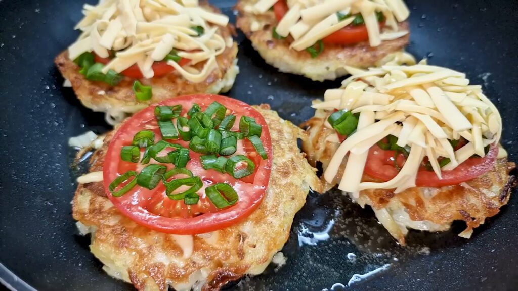 Bramboráčky zapečené s rajčaty, sýrem a zelenou cibulkou