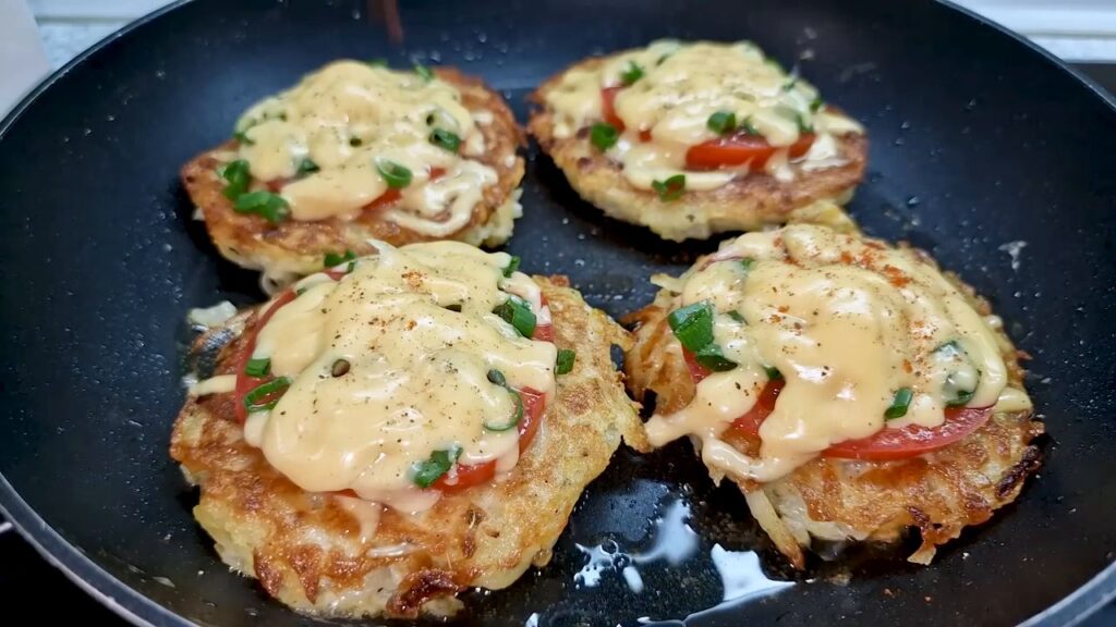 Bramboráčky zapečené s rajčaty, sýrem a zelenou cibulkou