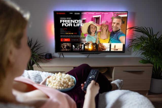 Woman watching TV series and movies on online streaming service at home