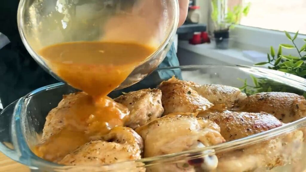 Baked delicious honey chicken thighs in a mild sauce with vegetables and potatoes