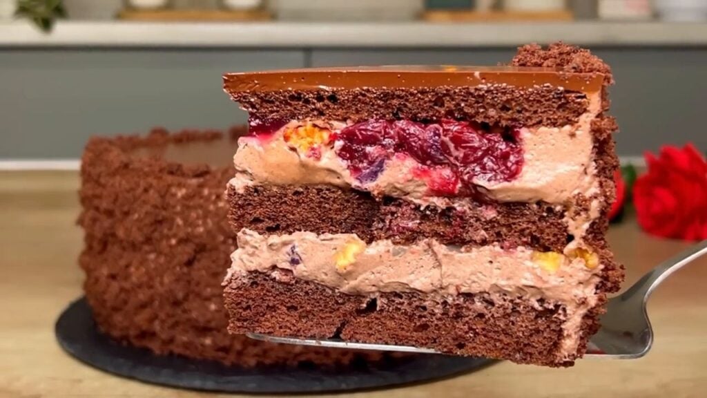 A wonderful layered cocoa cake with cocoa-cream cream made from sour cream and fruit