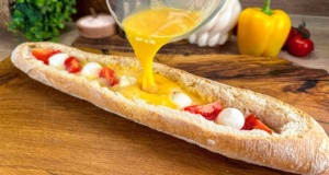 Zapečená křupavá plněná bageta s rajčaty, mozzarellou, šunkou a vaječnou směsí Zapečená křupavá plněná bageta s rajčaty, mozzarellou, šunkou a lahodnou vaječnou směsí