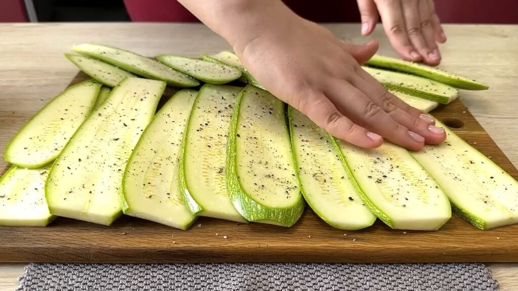 Smažená lahodná cuketa obalená ve vaječné směsi se zakysanou smetanou podávaná s rajčatovou omáčkou