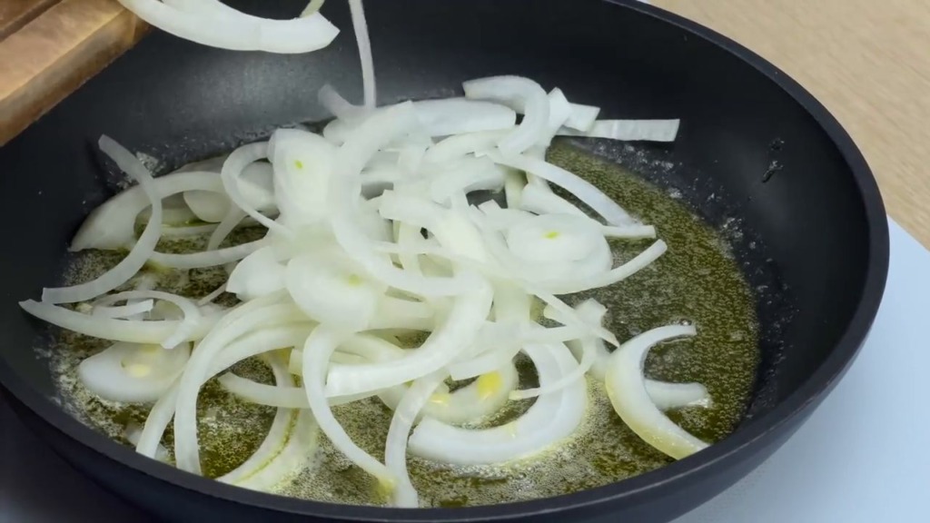 Zapečený cibulový koláč se zeleninou, sýrem feta, tvrdým sýrem a rajčaty ve tvaru pizzy