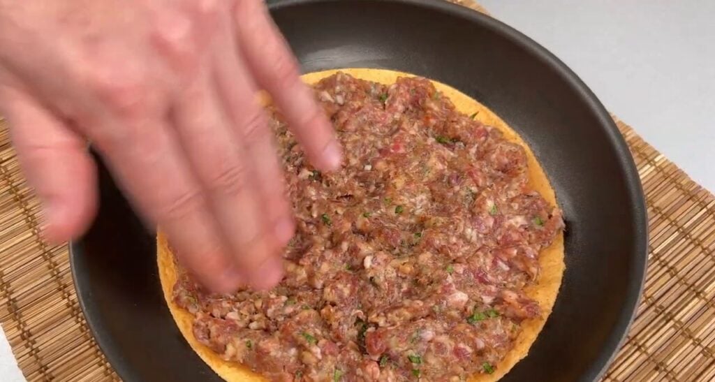 Křupavá tortilla ve tvaru pizzy s mletým masem, sýrem, rajčaty a mozzarellou - rychlá večeře na stole!