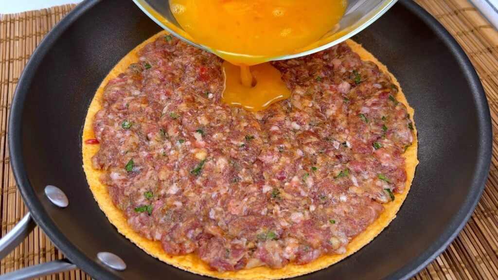 Křupavá tortilla ve tvaru pizzy s mletým masem, sýrem, rajčaty a mozzarellou - rychlá večeře na stole!