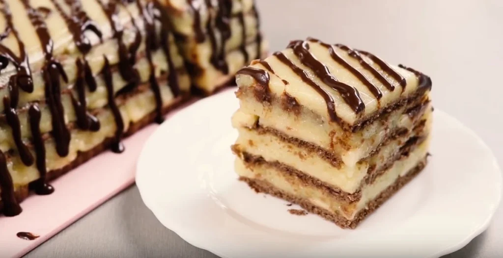 Tort de biscuiti fara coacere cu crema de portocale, banane si glazura de ciocolata