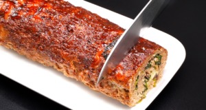 Gurmánská masová roláda plněná špenátem, žampiony a sýrem, podávaná s jemnou bramborovou kaší Gurmánská masová roláda plněná špenátem, žampiony a sýrem, potřená sladkastou směsí, podávaná s bramborovou kaší