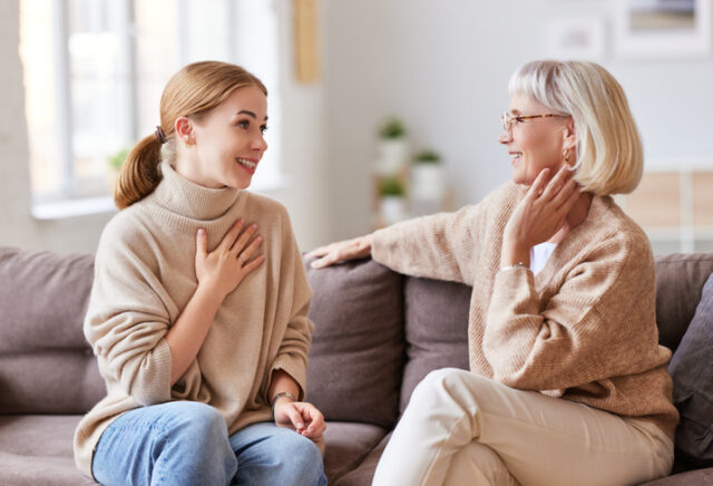 Mother and daughter speaking on couch