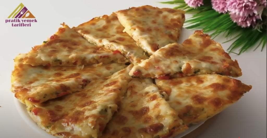 Zapečená bramborová pizza s voňavou restovanou zeleninou a rozpuštěným sýrem ve tvaru pizzy