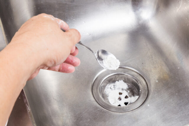 Baking soda poured to unclog drainage system at home.