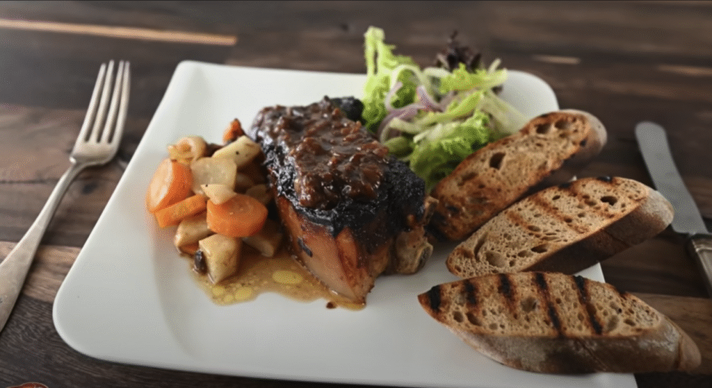 Pečený vepřový bůček s pikantní švestkovou omáčkou, restovanou zeleninou a svěžím fenyklovým salátem