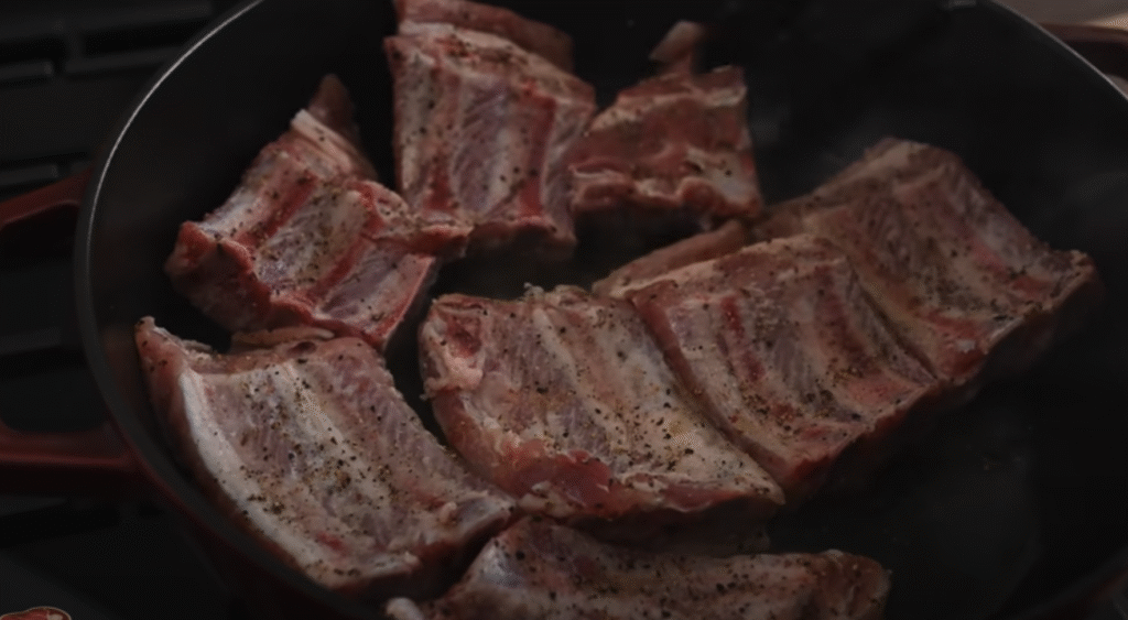 Gurmánská vepřová žebírka s česnekem v rajčatové omáčce s restovanými houbami se slaninou a bagetou