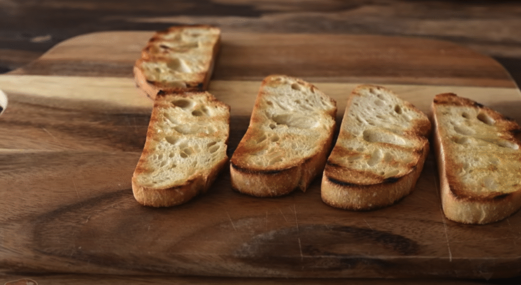 Gurmánská vepřová žebírka v česnekovo-rajčatové omáčce s houbami, slaninou a křupavou bagetkou