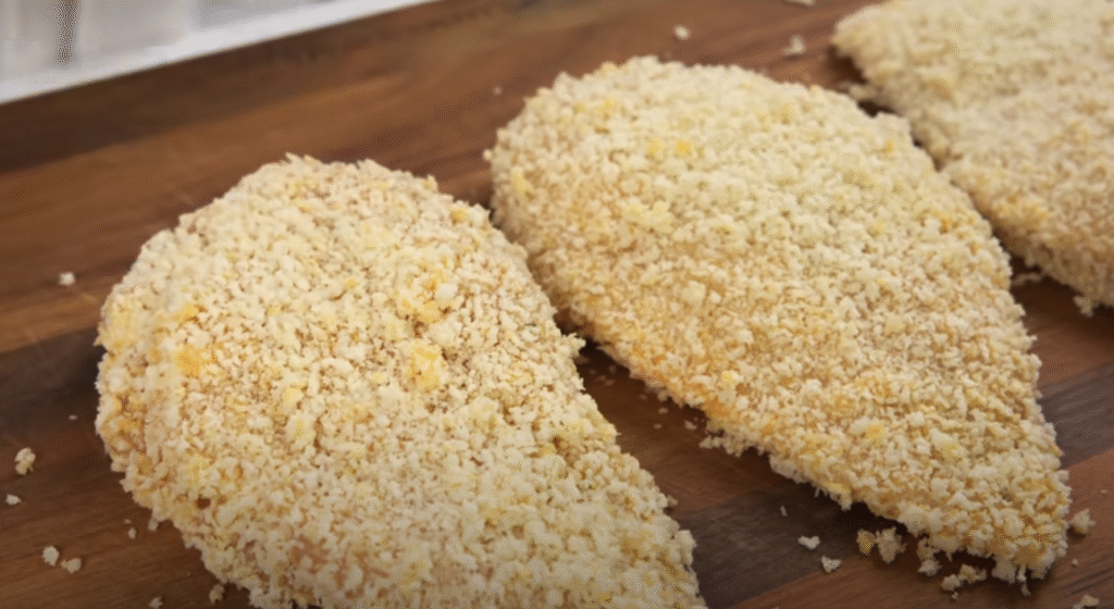 Křupavá kuřecí prsa, obalená v zlatavé panko strouhance a plněná voňavou bylinkovo-česnekovou náplní