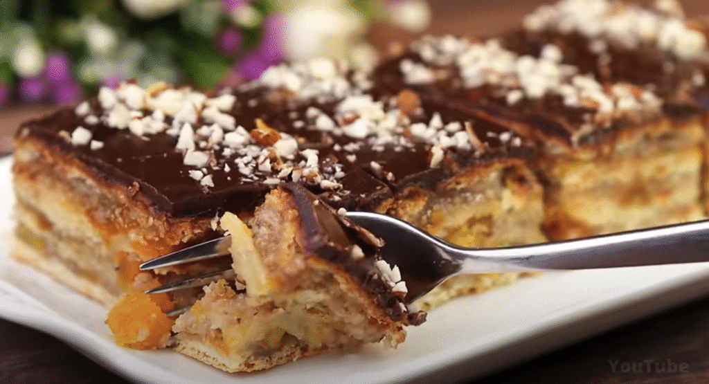 Vrstvený meruňkový koláč s ořechy, koňakem a čokoládovou polevou