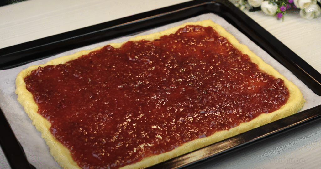 Lahodný drobenkový koláč ze zakysané smetany s oblíbeným džemem – tradiční sladká pochoutka plná křupavé drobenky