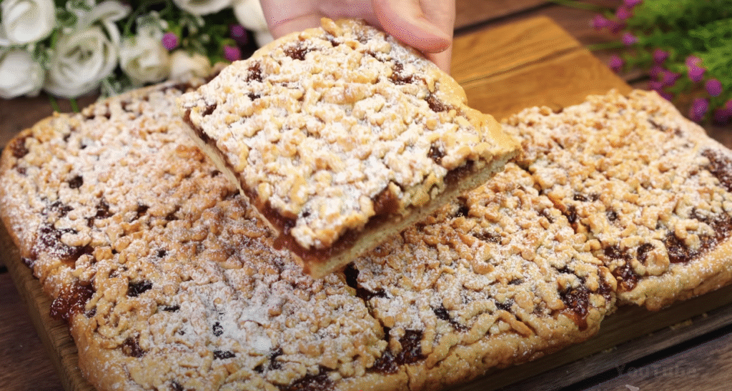 Lahodný drobenkový koláč ze zakysané smetany s oblíbeným džemem – tradiční sladká pochoutka plná křupavé drobenky