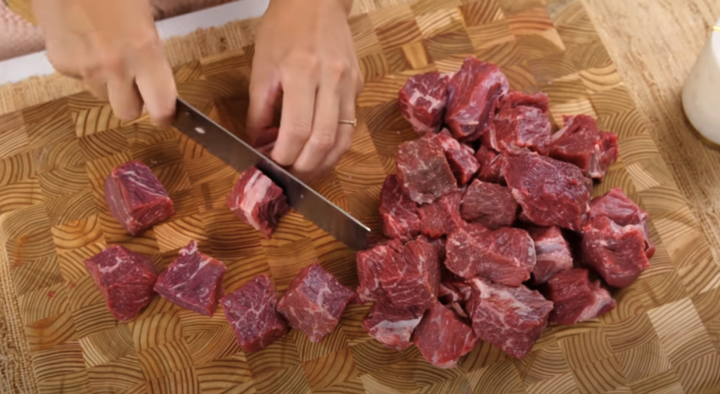 Pomalu dušené hovězí na červeném víně s kořenovou zeleninou a žampiony, podávané s jemnou bramborovou kaší