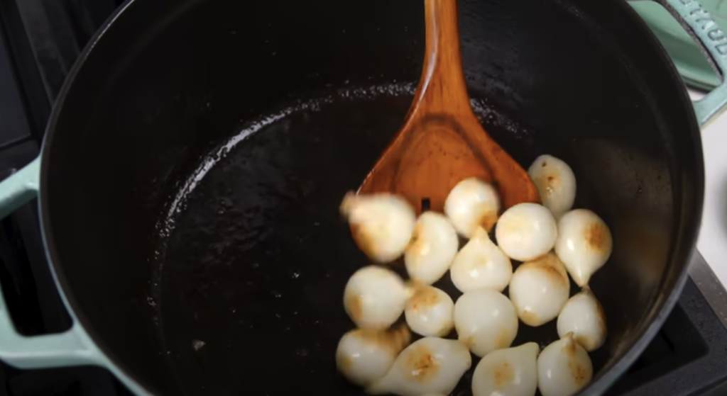 Pomalu dušené hovězí na červeném víně s kořenovou zeleninou a žampiony, podávané s jemnou bramborovou kaší