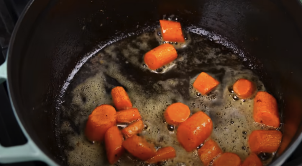 Pomalu dušené hovězí na červeném víně s kořenovou zeleninou a žampiony, podávané s jemnou bramborovou kaší