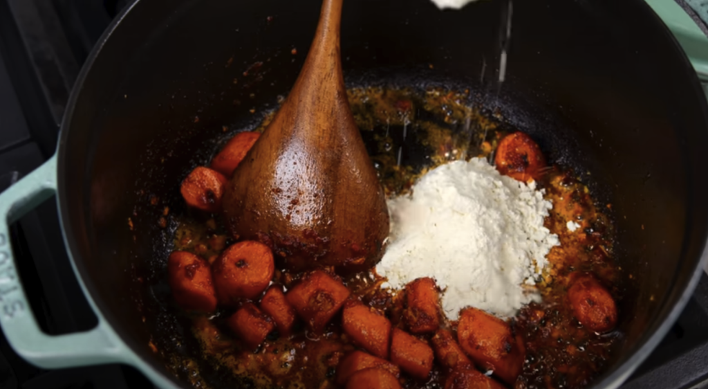 Pomalu dušené hovězí na červeném víně s kořenovou zeleninou a žampiony, podávané s jemnou bramborovou kaší