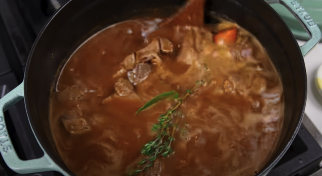 Pomalu dušené hovězí na červeném víně s kořenovou zeleninou a žampiony, podávané s jemnou bramborovou kaší