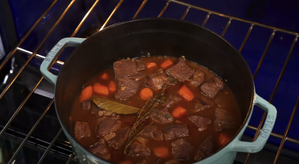 Pomalu dušené hovězí na červeném víně s kořenovou zeleninou a žampiony, podávané s jemnou bramborovou kaší