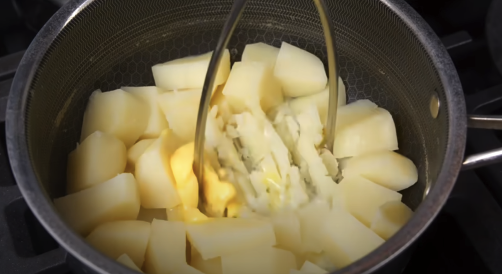 Pomalu dušené hovězí na červeném víně s kořenovou zeleninou a žampiony, podávané s jemnou bramborovou kaší