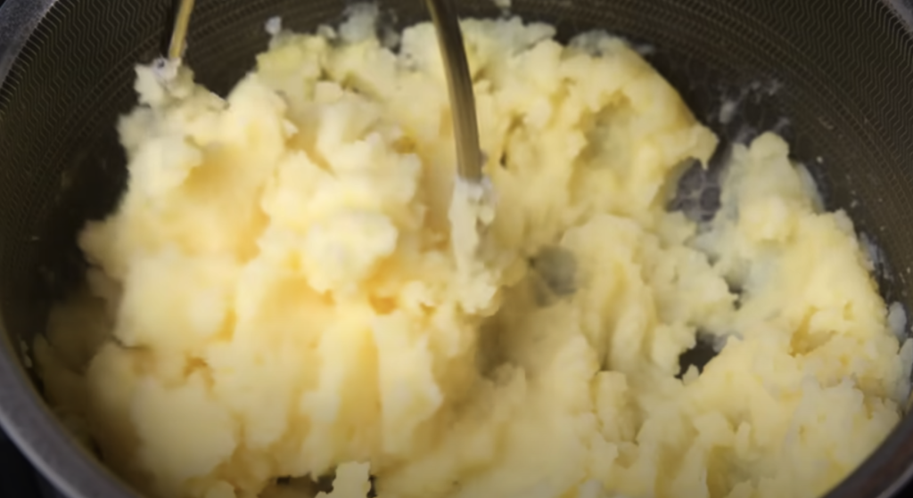 Pomalu dušené hovězí na červeném víně s kořenovou zeleninou a žampiony, podávané s jemnou bramborovou kaší