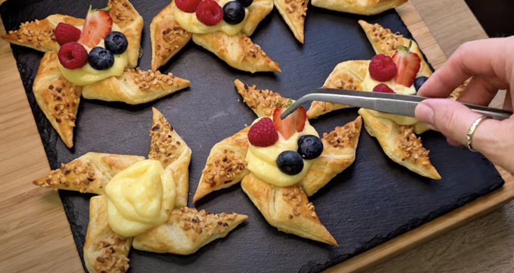 Křehké hvězdičky z listového těsta s vanilkovým pudinkem, ovocem a lískovými oříšky