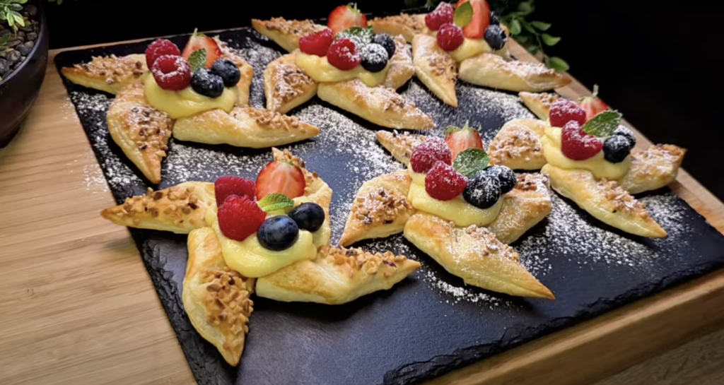 Křehké hvězdičky z listového těsta s vanilkovým pudinkem, ovocem a lískovými oříšky