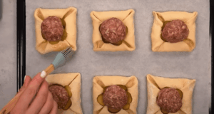 Výborný recept na masové kuličky obalené v listovém těstu, sypané sýrem!