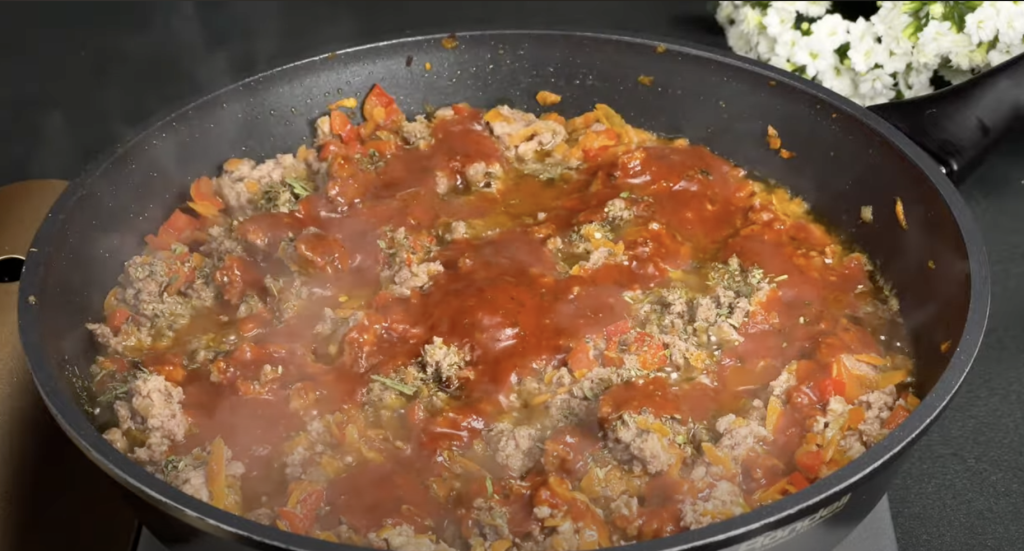 Slaný bramborový koláč ve tvaru pizzy s mletým masem, zeleninou a mozzarellou