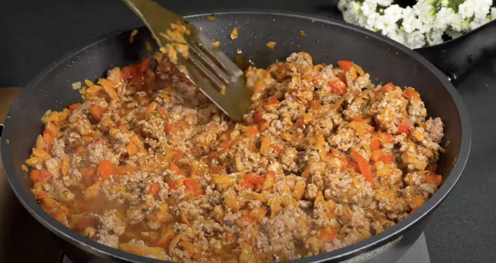 Slaný bramborový koláč ve tvaru pizzy s mletým masem, zeleninou a mozzarellou