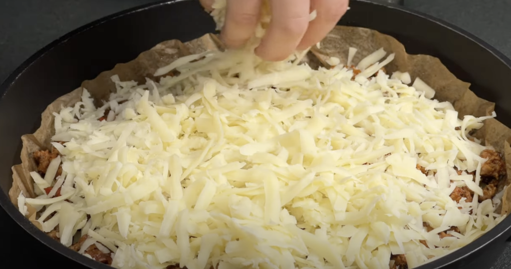 Slaný bramborový koláč ve tvaru pizzy s mletým masem, zeleninou a mozzarellou