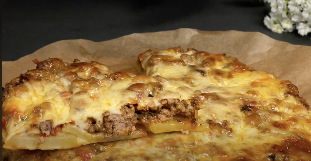 Slaný bramborový koláč ve tvaru pizzy s mletým masem, zeleninou a mozzarellou