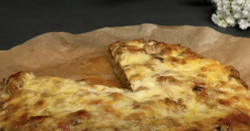 Slaný bramborový koláč ve tvaru pizzy s mletým masem, zeleninou a mozzarellou